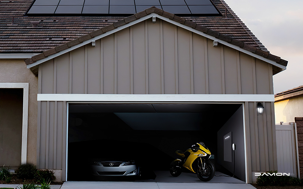 Damon HyperSport HS connected up to an electric motorcycle charger next to a silver lexus in a home car garage