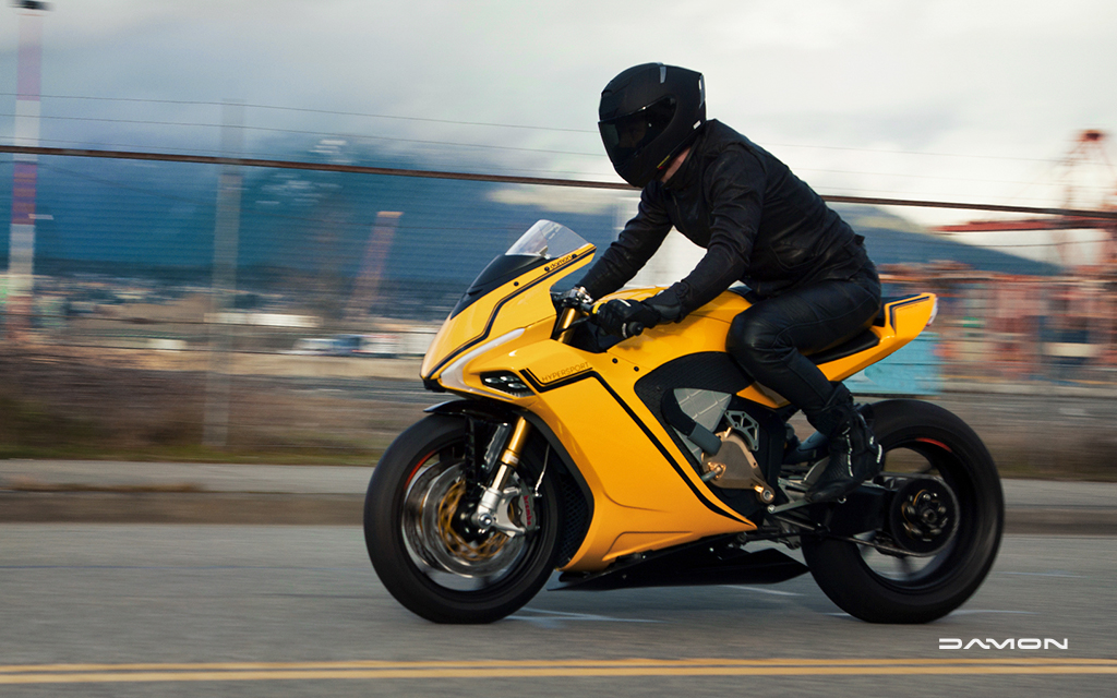Motorcycle driver on a gold Damon HyperSport on highway
