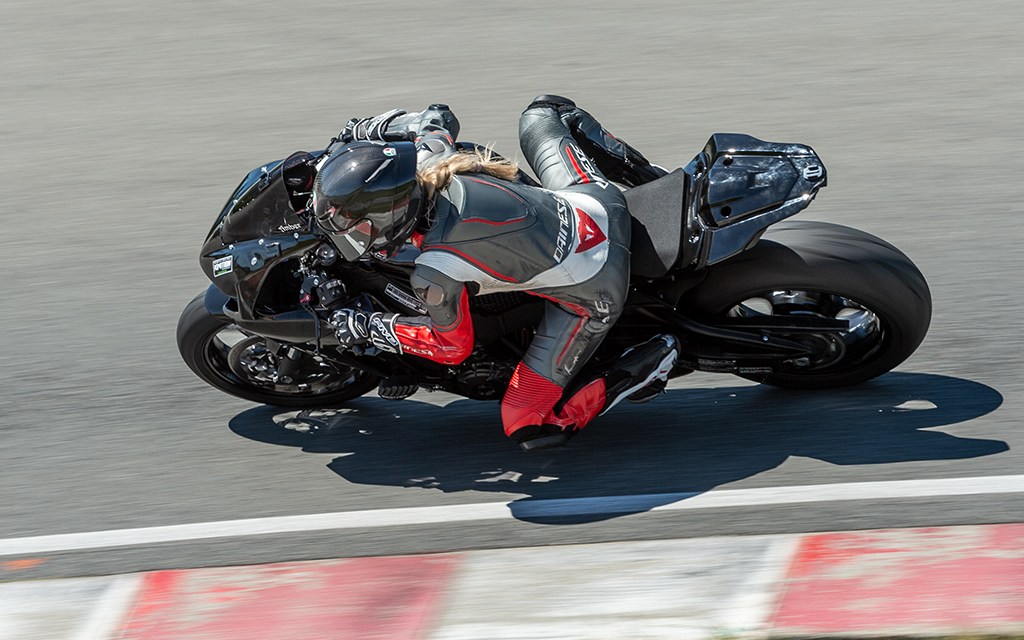 Amber Spencer, from Damon Motorcycles, riding a black sport bike at fast speed at a track day in Vancouver